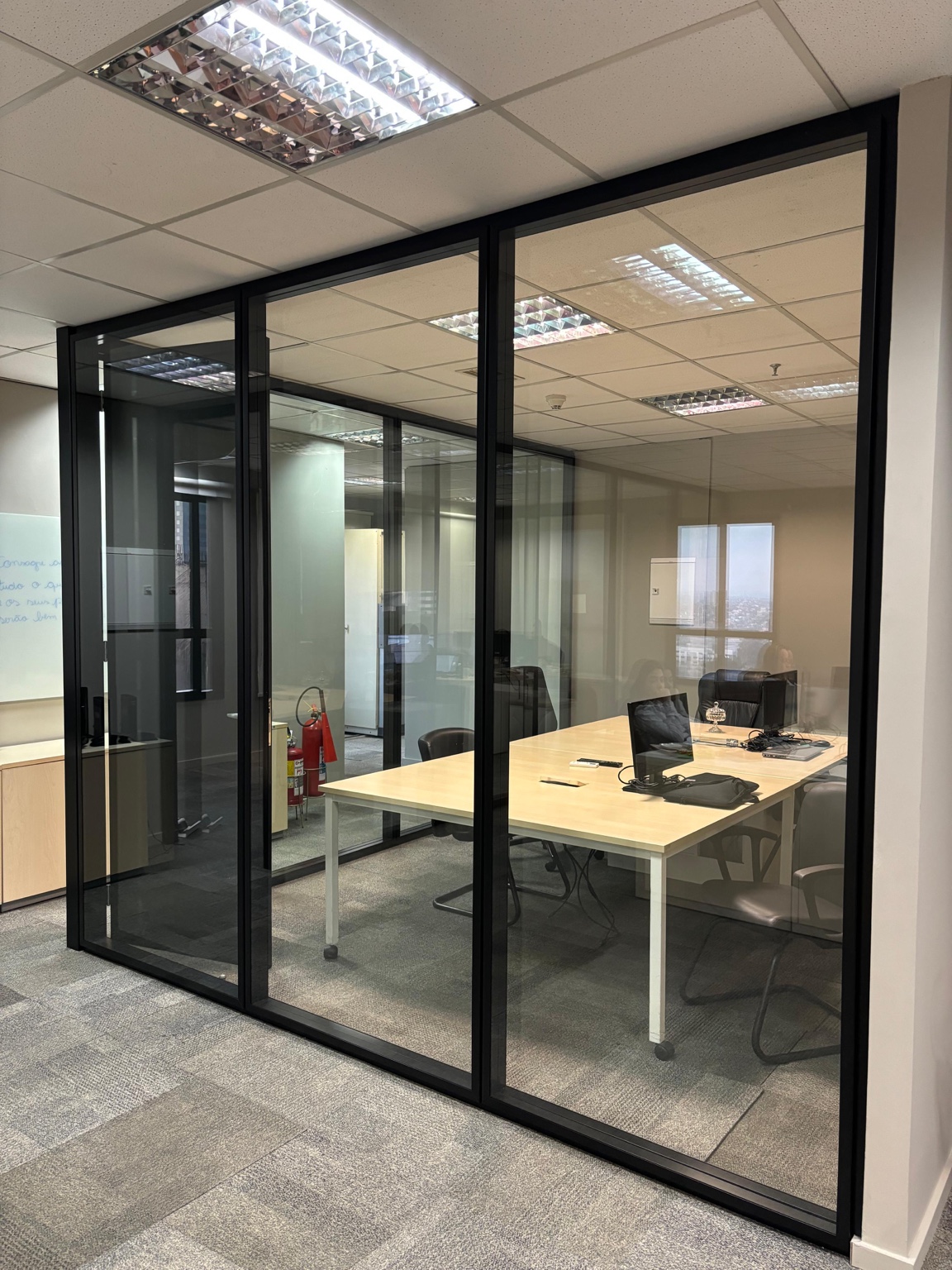 Sala corporativa com divisórias de vidro e perfis pretos em projeto Formi