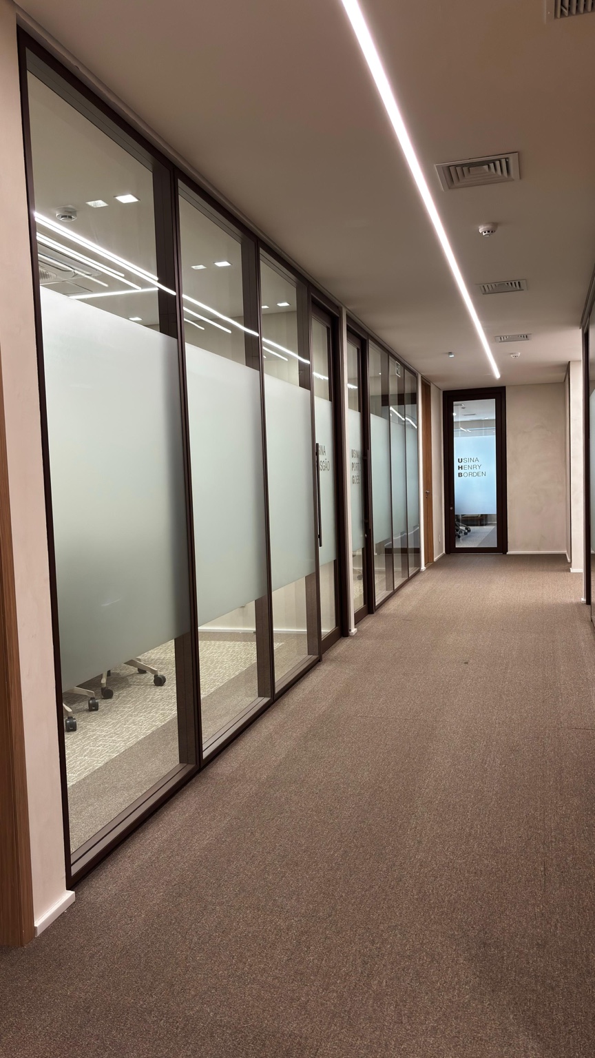 Corredor com divisórias de vidro e faixas de privacidade em projeto Formi